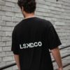Black crew-neck tee by brick wall