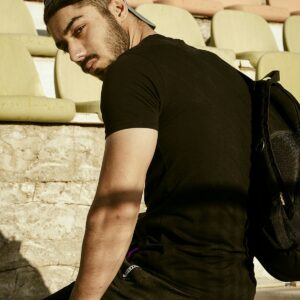 Black tee and pants, seated